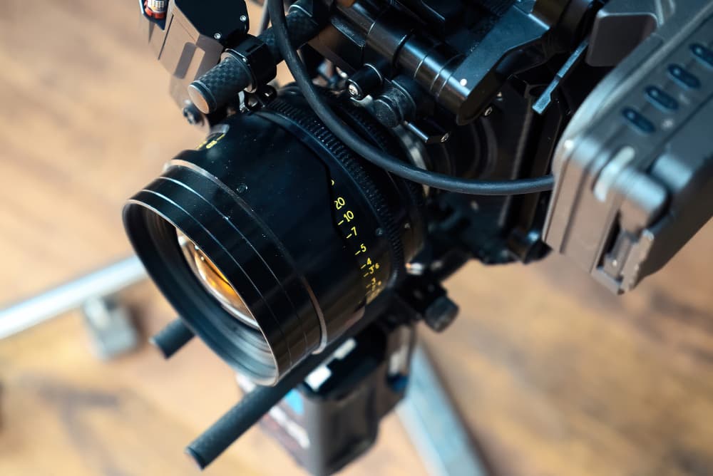 Professional videographer using cinema-grade camera equipment with gimbal stabilizer filming high-quality video content in studio